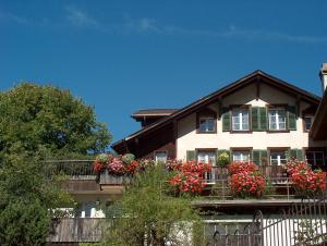 een huis met bloembakken op het balkon bij FERIENWOHNUNGEN Chalet Hohturnen in Grindelwald