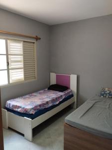 een slaapkamer met twee bedden en een raam bij Casa azul da Serra in São Pedro