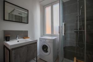 a bathroom with a washing machine and a sink at Faubourg des voyageurs 6 - T3 climatisé 4 personnes - proche axe autoroute in Saran