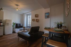 a living room with a table and a chair at Faubourg des voyageurs 6 - T3 climatisé 4 personnes - proche axe autoroute et gare in Saran