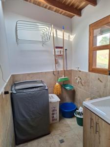 a bathroom with a trash can and a sink at Habitación en Casa San Miguel, Vereda El Plan, Santa Elena in Medellín