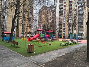un parque con parque infantil con tobogán y bancos en Apartment I&M, en Osijek