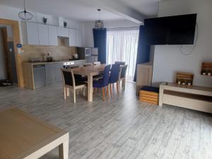 a kitchen and dining room with a table and chairs at Bajka w Gliczarowie in Bukowina Tatrzańska +16 photos