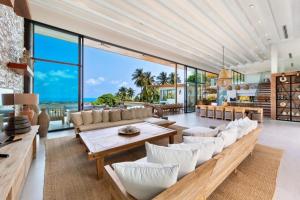 an open living room with white furniture and a view of the ocean at Amazing Luxury Villa in Ban Thung