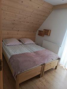 a bedroom with a wooden bed in a attic at Bajka w Gliczarowie in Bukowina Tatrzańska