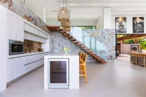 a kitchen with a white counter and a staircase at Amazing Luxury Villa in Ban Thung