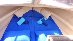 saco de dormir azul en una tienda con 2 almohadas azules en Varuna en Sur de Tenerife, en San Miguel de Abona