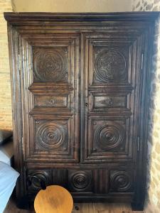an old wooden cabinet with wooden patterns on it at La Maison du Tisserand maison entière à Bécherel in Bécherel