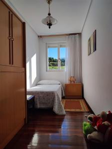 a bedroom with a bed and a window at El Molino de Mateo in Ribamontan al Monte