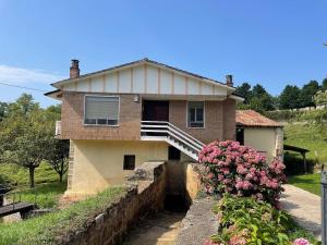 a house with a porch and flowers in front of it at El Molino de Mateo in Ribamontan al Monte