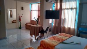 Habitación de hotel con cama, mesa y TV. en Hotel Tumburagua Inn Ltda, en Neiva