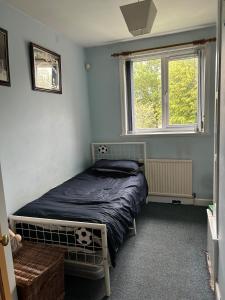 une chambre avec un lit et une fenêtre dans l'établissement Cosy 3 bedroom house to rent, à Manchester