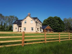 a large house behind a wooden fence at The Little House in Ballynacarrow