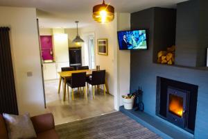 sala de estar con mesa de comedor y chimenea en Canyon Cottage, en Pont-Nedd-Fechan