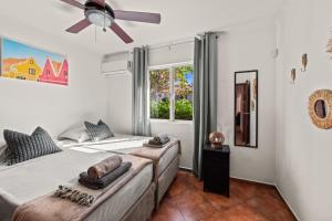 a bedroom with two beds and a ceiling fan at Villa Panlefi - Marbella Estate in Jan Thiel +34 photos