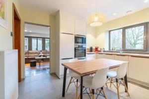 a kitchen and dining room with a wooden table and chairs at Charmette, cozy home for 9p in La-Roche-en-Ardenne