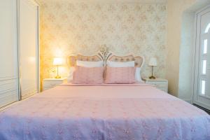 a bedroom with a pink bed with pink pillows at Luxurious Villa with Huge Garden, Terrace & Outdoor Space in Bucharest +35 photos