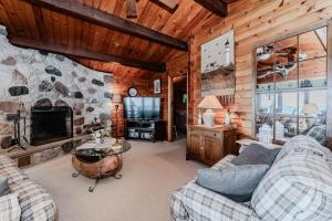 ein Wohnzimmer mit Sofas und einem Steinkamin in der Unterkunft Rustic Waterfront Cottage W Hot Tub in Lions Head