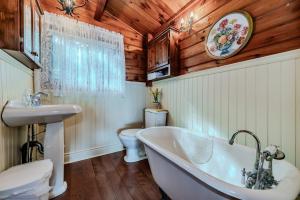ein Badezimmer mit Badewanne, Toilette und Waschbecken in der Unterkunft Rustic Waterfront Cottage W Hot Tub in Lions Head + 32 Fotos