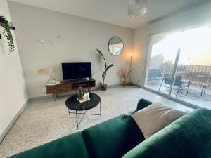 TV a/nebo společenská místnost v ubytování Joli appartement lumineux et calme