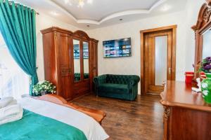 - une chambre avec un lit et une chaise verte dans l'établissement Luxurious Villa with Lush Garden and Huge Terrace near Herastrau Park, à Bucarest