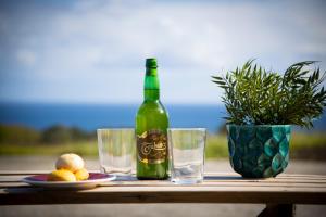 a bottle of wine and two glasses on a table at Playa del Silencio 2 in Castañeras