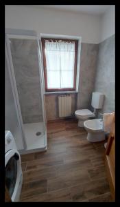 a bathroom with two toilets and a shower at Il Gatto Ombrellaio - Gateway to Stresa, Lake Maggiore and Mountains in Stropino