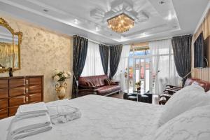 a bedroom with a large white bed and a chair at High-end 3BR Apartment - Private Garden, Terrace & BBQ in Bucharest