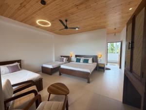 a hotel room with two beds and a couch at Weligama Ocean Breeze in Weligama