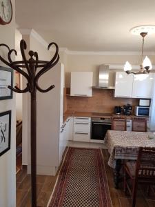 a kitchen with a table and a dining room at Kussbach apartman in Sárospatak
