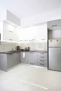 a white kitchen with white cabinets and appliances at #1 Ioanna Apartments in Thessaloniki +11 photos