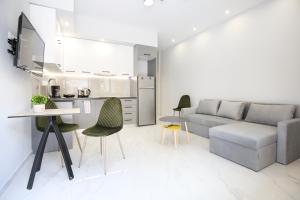 a living room with a couch and a table and chairs at #1 Ioanna Apartments in Thessaloniki
