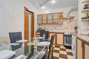 a kitchen with a glass table and chairs in it at High-end 3BR Apartment - Private Garden, Terrace & BBQ in Bucharest +29 photos