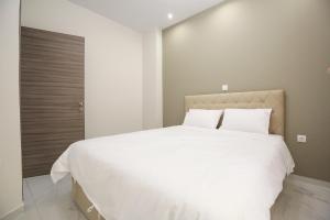 a bedroom with a large bed with white sheets at #2 Ioanna Apartments in Thessaloniki