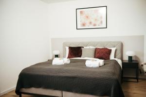 une chambre avec un grand lit avec des serviettes dessus dans l'établissement Feel Home Apartments - Seeblick - Bergblick - Parkplatz, à Emmetten