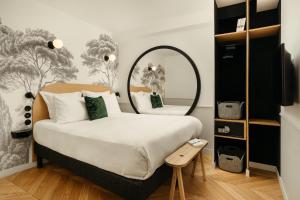 Un dormitorio con una cama grande y un espejo. en My Maison In Paris Montmartre, en París