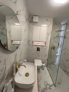 a bathroom with a toilet and a sink and a mirror at The Perfect Space - NEW1Bedroom & Parking in Târgu-Mureş