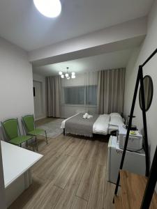 a bedroom with a bed and two green chairs at 41-40 этаж Отель Bon Dian in Astana
