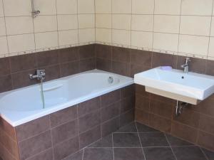 a bathroom with a tub and a sink at House Dolenja Trebuša in Dolenja Trebuša