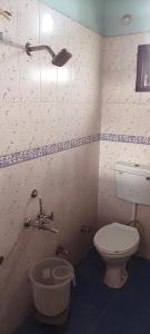 a bathroom with a toilet and a sink and a light at Hotel D Pal in Kandāghāt +25 photos