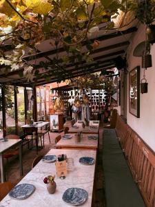 a restaurant with long tables and chairs and trees at Pensionat Krukan in Mölle
