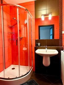 an orange bathroom with a sink and a shower at LUX apartament in Warsaw +15 photos