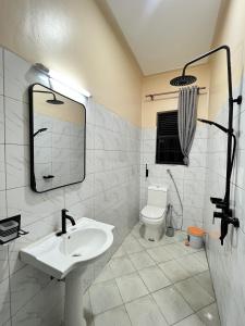 a white bathroom with a sink and a toilet at Supreme Apartments in Kansiri +134 photos