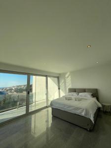 a white bedroom with a bed and a large window at Casa Klei in Ulcinj