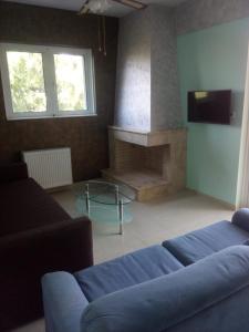 a living room with a couch and a fireplace at Rafina suits in Rafina