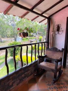 un banc sur un balcon donnant sur un jardin dans l'établissement Casa Encanto, naturaleza y comodidad, à Socorro