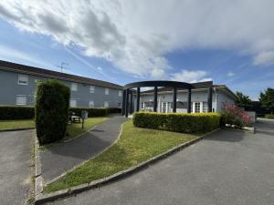 a building with a gazebo in a parking lot at Kyriad Direct Reims in Reims