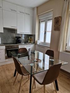 a kitchen with a glass dining room table and chairs at Valle del Nalon in San Martín del Rey Aurelio