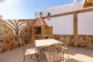 a patio with a table and chairs and a stone oven at Meloneras Hills Private Villa in Meloneras