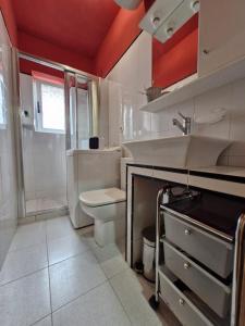 a bathroom with a white toilet and a sink at Valle del Nalon in San Martín del Rey Aurelio